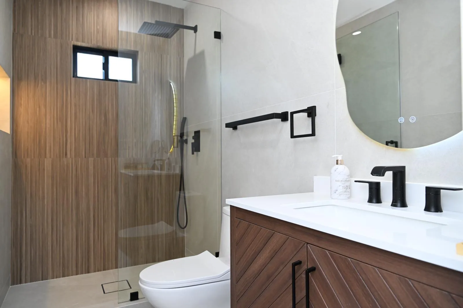 Walk-in shower with wood-look accent wall after a bathroom remodel