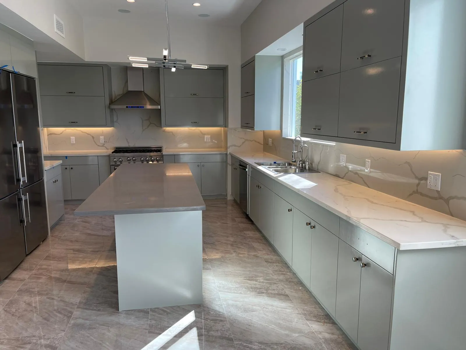 Gray kitchen with long waterfall quartz island