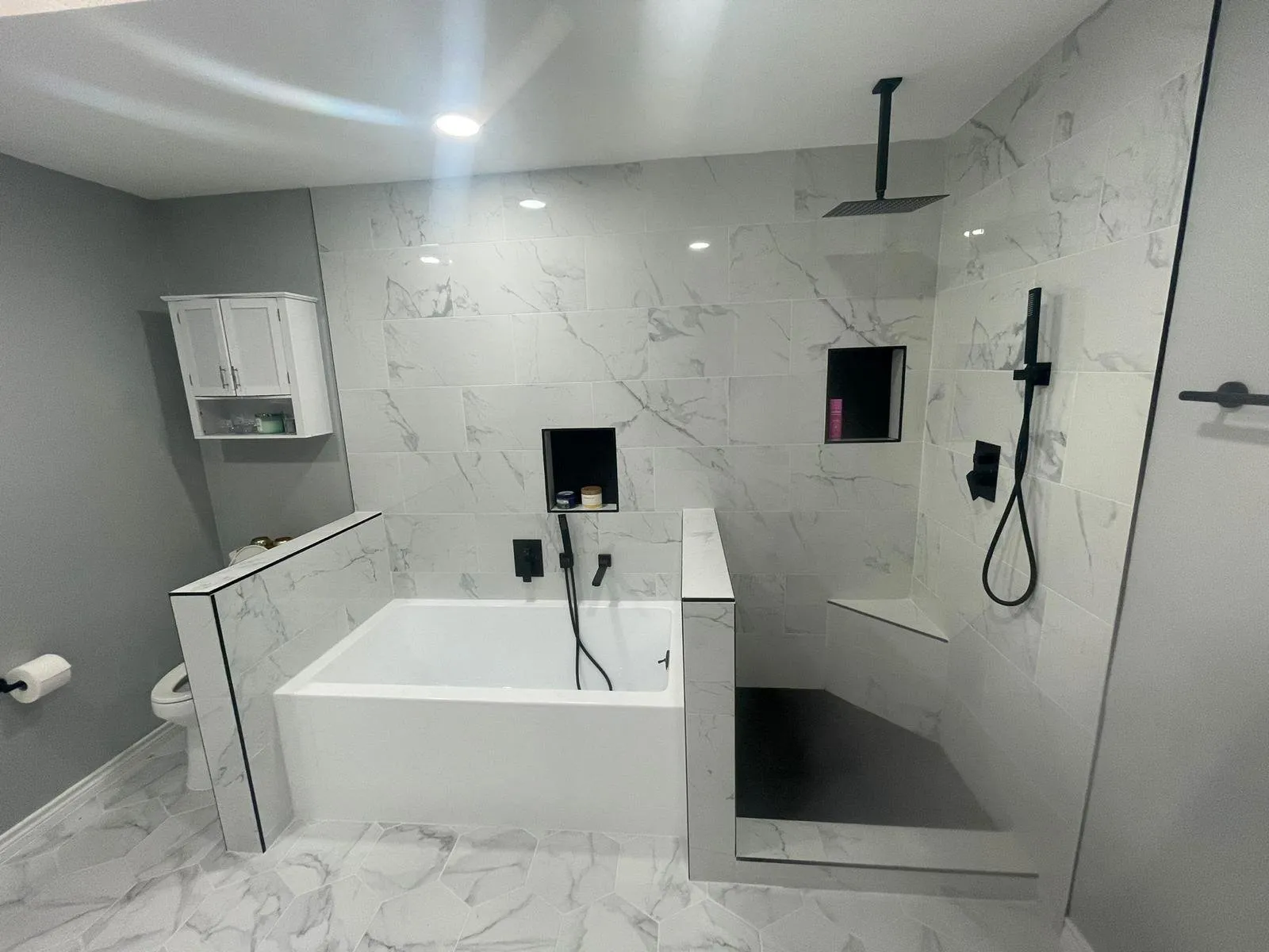 Soaking tub behind a tiled half wall, Dallas bathroom remodel