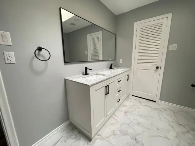 New white double vanity with marble-look top after the bathroom remodel, Dallas