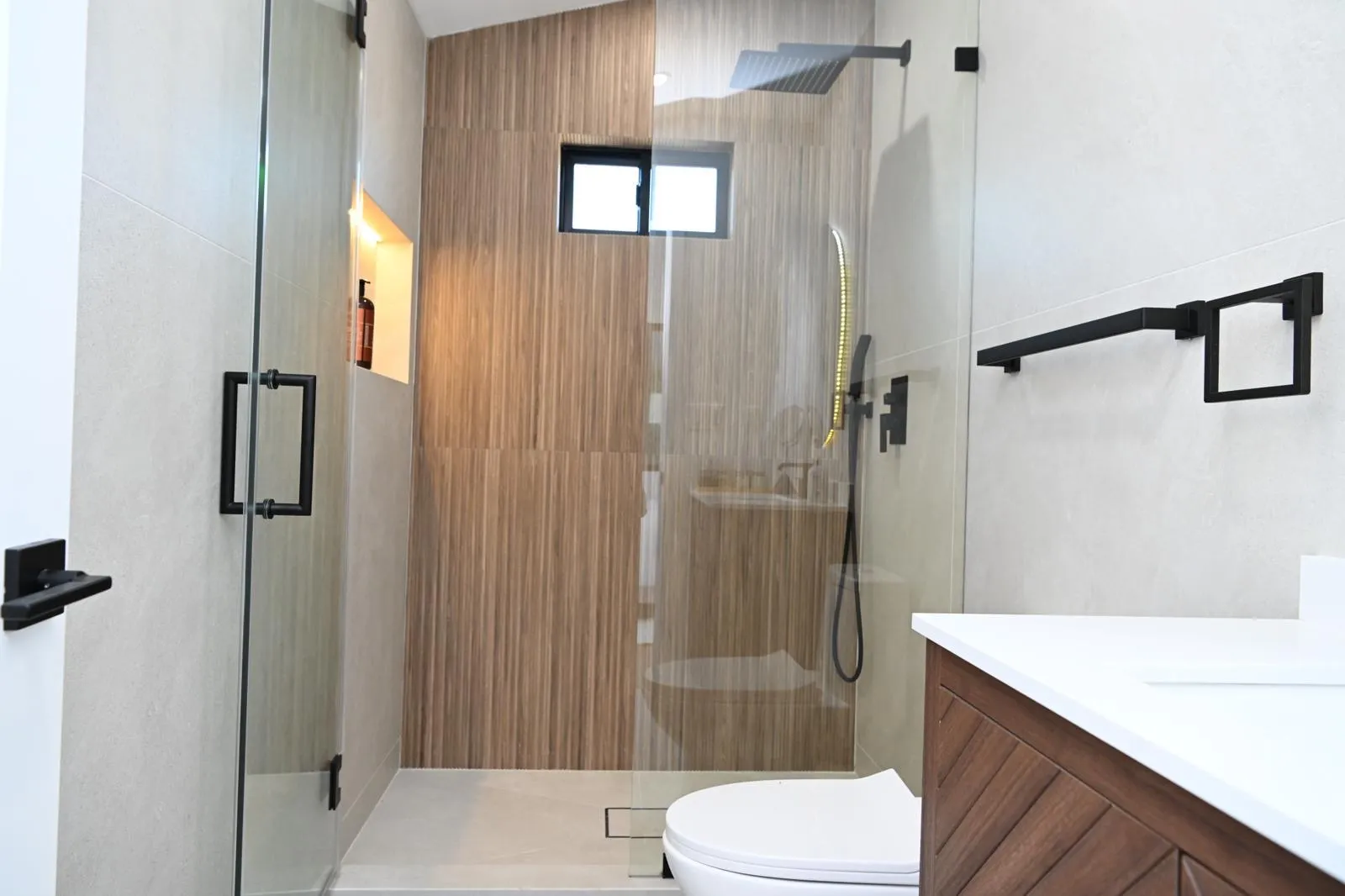 Frameless glass shower and wood vanity after a bathroom remodel
