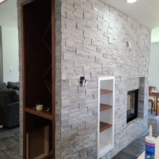 Stacked stone fireplace wall with built-in shelves