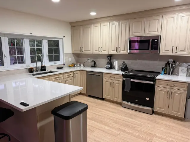 Kitchen with cream cabinets, white quartz counters and new appliances