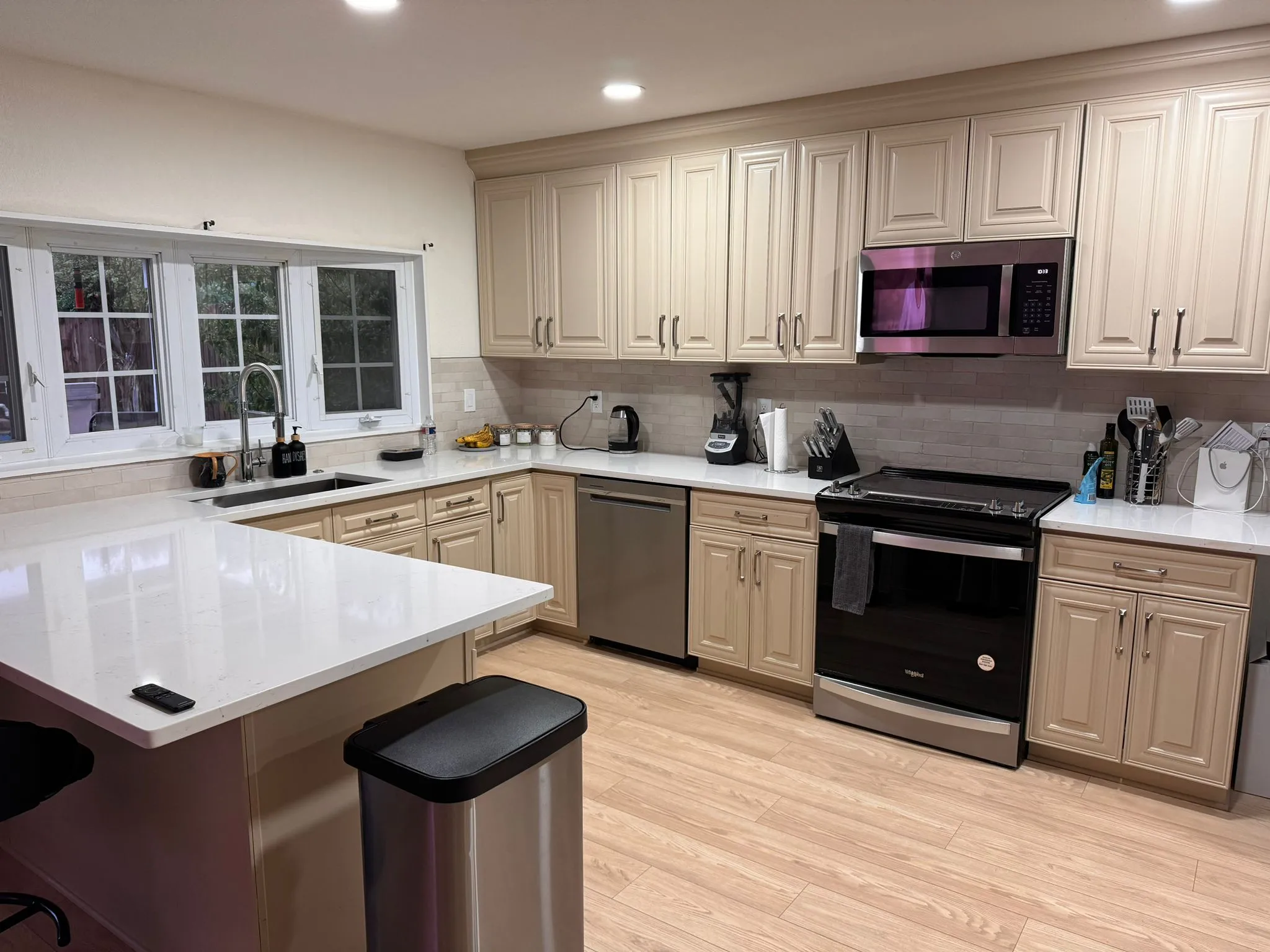 Kitchen with cream cabinets, white quartz counters and new appliances