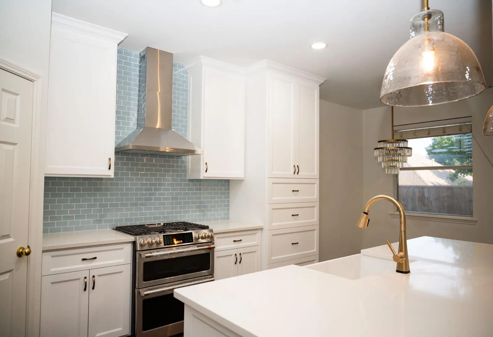 Range wall with glass tile backsplash and stainless hood