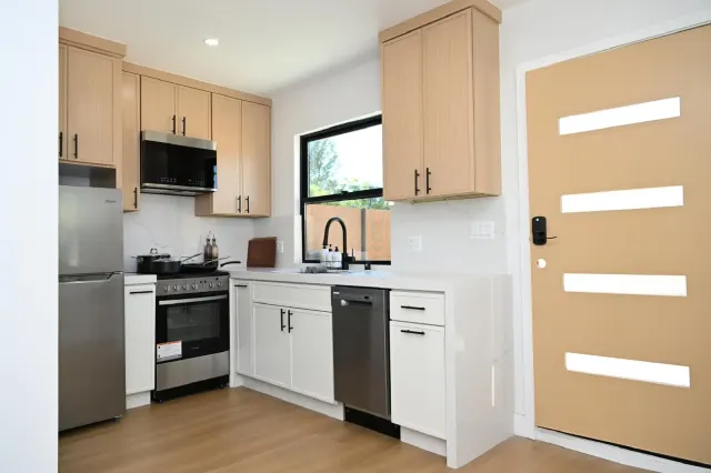 Compact kitchen with light wood cabinets and white quartz counters