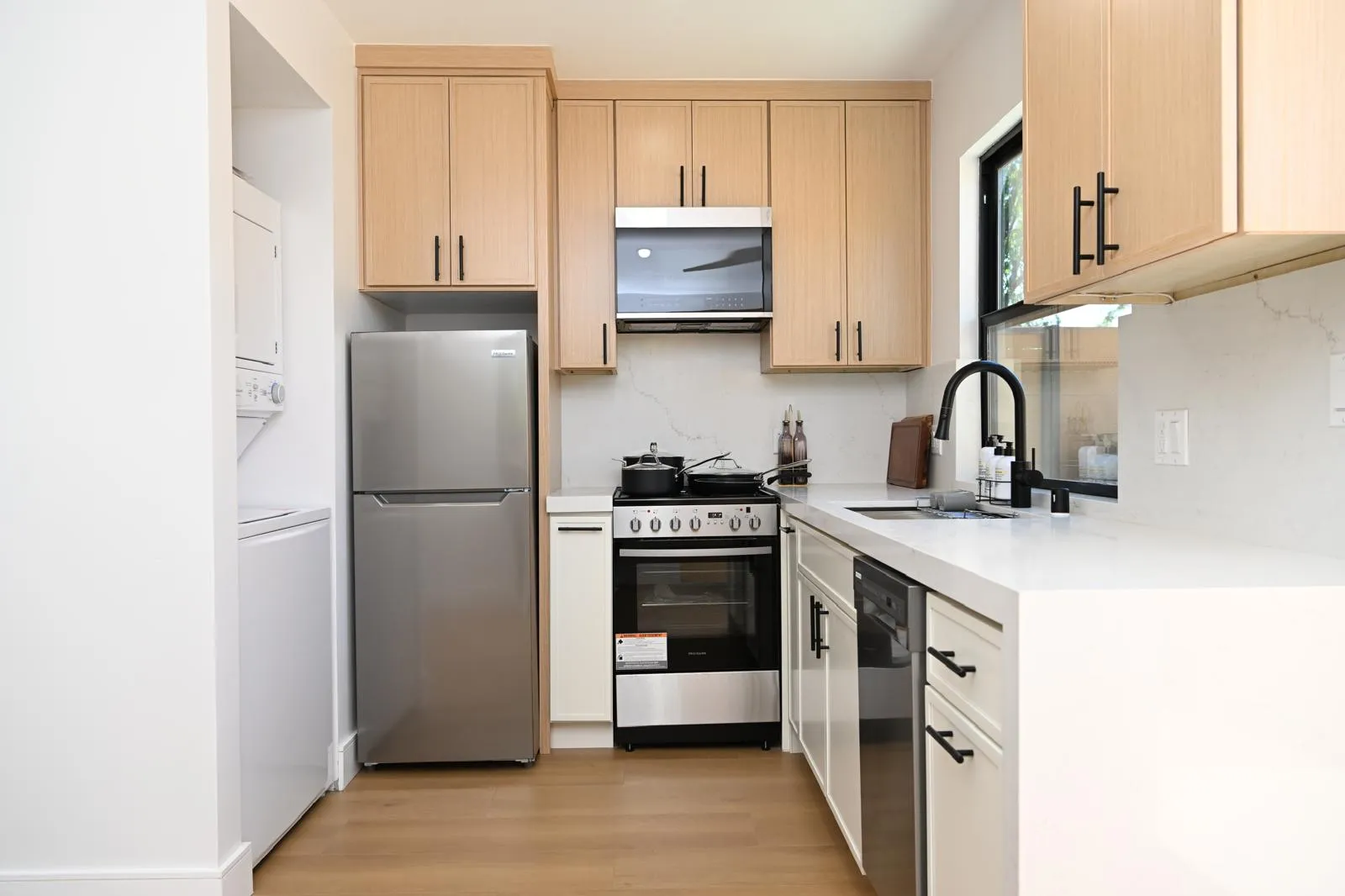 Light wood kitchen with stainless refrigerator and range
