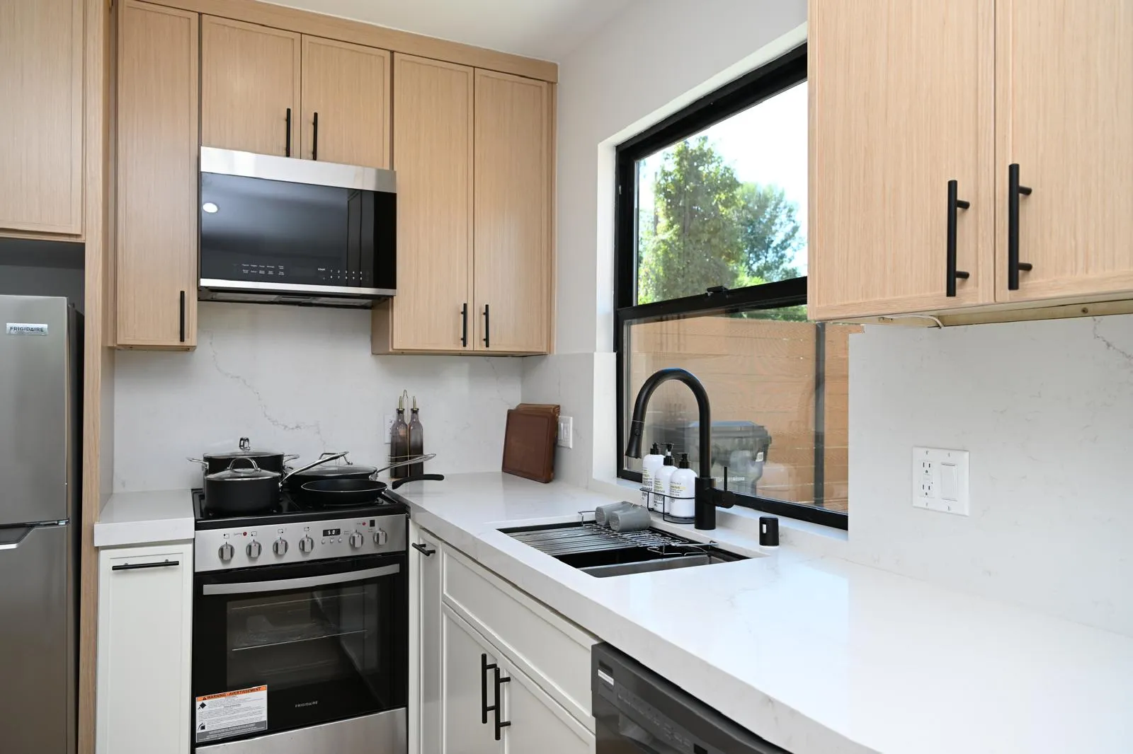 Range and microwave wall in a light wood kitchen