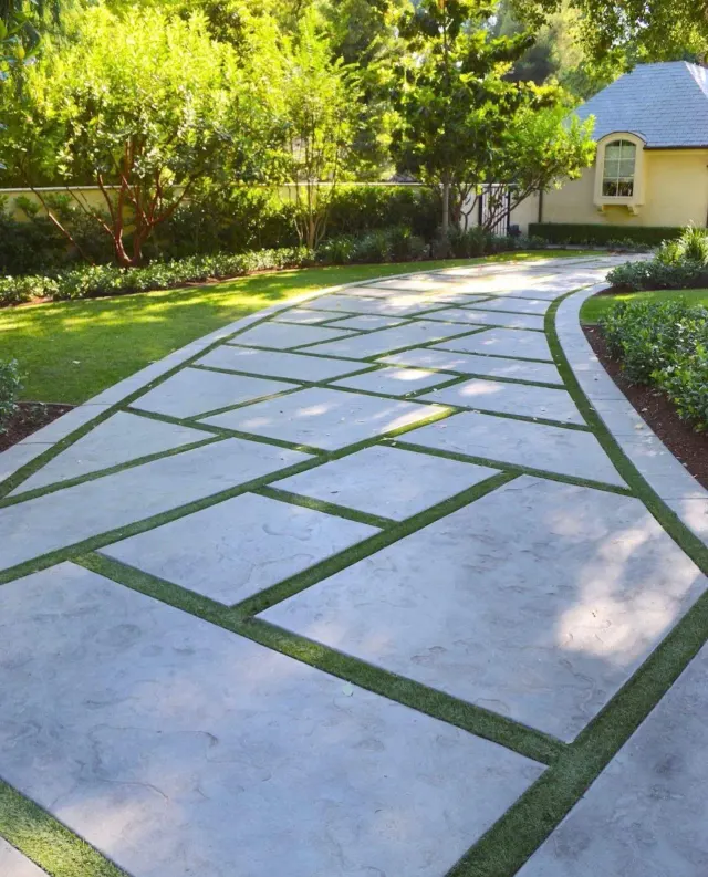 Curved walkway of large concrete pavers with turf joints