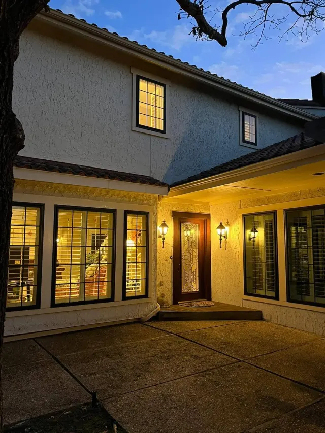 Two-story home at dusk with new dark-frame grid windows