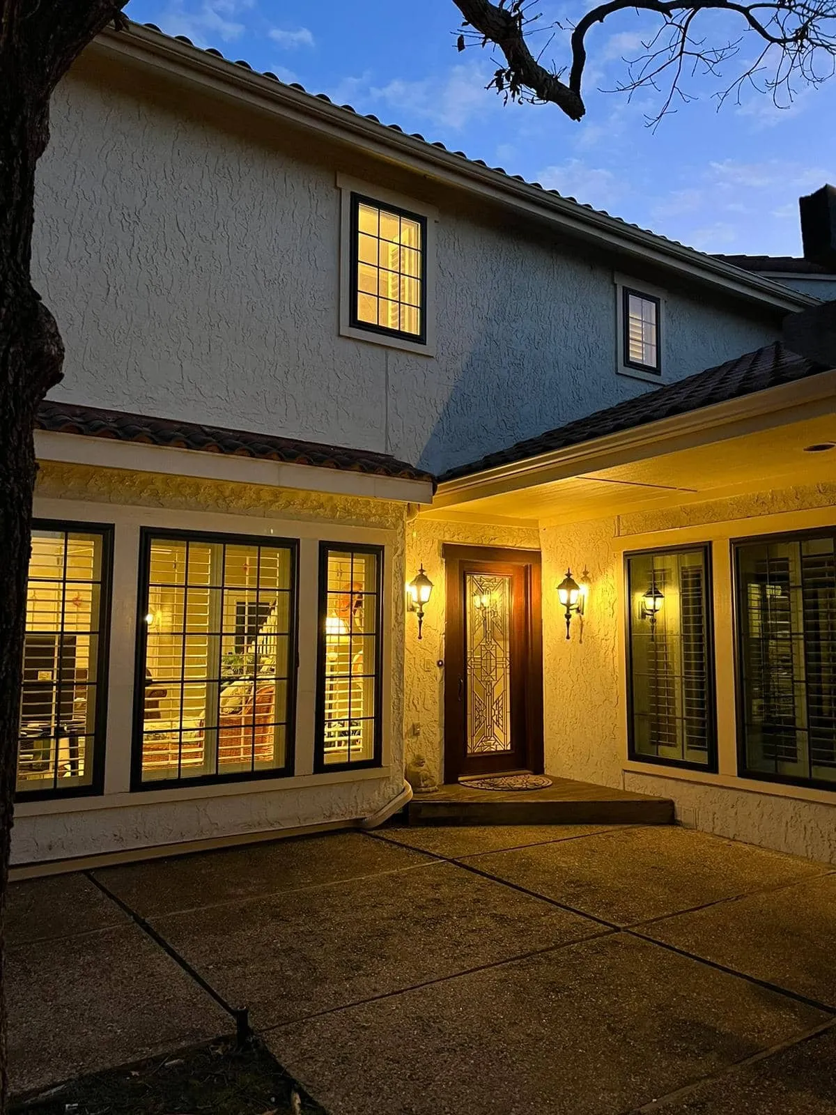 Two-story home at dusk with new dark-frame grid windows